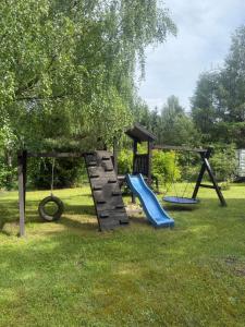 a playground with two swings and a slide at Tleniowo Domek in Tleń