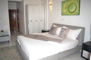 a bedroom with a large bed with white sheets and pillows at jPALACE in Bonamoussadi