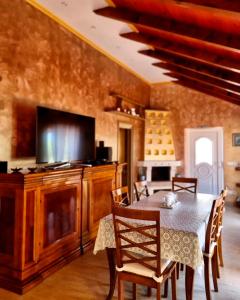 a dining room with a table with chairs and a television at Vila s bazenom Mavrinac in Nerezine