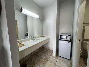 a bathroom with a sink and a microwave at Century Inn in Dallas