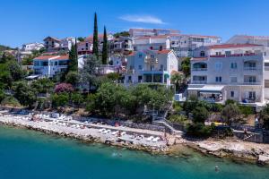 a group of buildings on a beach next to the water at Villa Obad Guest House in Neum