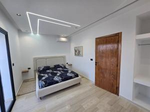 a bedroom with a bed and a wooden door at Dar Aalya in Djerba +14 photos