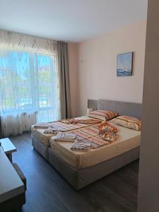 a bedroom with a bed and a large window at Fits Guest House in Primorsko