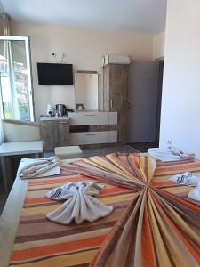 a bedroom with a large bed with towels on it at Fits Guest House in Primorsko