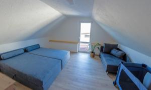 a living room with a blue couch and a window at Tarasova in Zbudský Rokytov