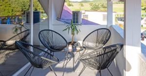 a patio with three chairs and a table on a balcony at Tarasova in Zbudský Rokytov