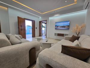 a living room with couches and a tv on the wall at Dar Aalya in Djerba