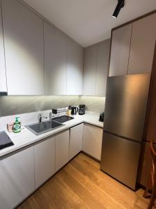 a kitchen with white cabinets and a stainless steel refrigerator at Harbour Light Residence in Bjeliši