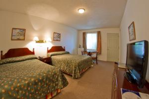 a hotel room with two beds and a flat screen tv at Family Inn in San Rafael