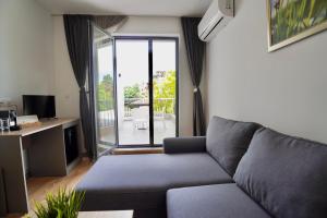 a living room with a couch and a sliding glass door at Marina Sarafovo by Cosher in Burgas