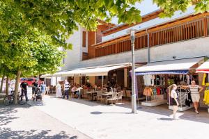 a street with people sitting outside a restaurant at Jacht Apartmanok in Balatonfüred