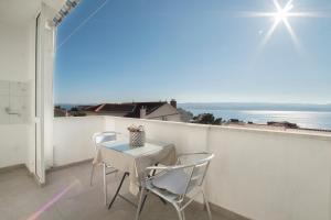 a table and chairs on a balcony with a view of the ocean at Sunny house KIMI in Omiš