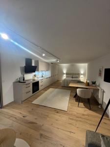a large white room with a bed and a table at Casa Souterrain in Immenstaad am Bodensee +3 photos