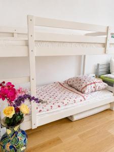 a white bunk bed in a room with flowers in a vase at Gemütliche und Zentrumsnahe Wohnung in Goslar in Goslar