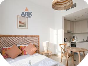 a bedroom with a bed and a table and a kitchen at Ark Living Stay in Yas Island in Yas Island