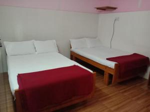 two twin beds in a room with a red seat at Arrow mansion in Kolli Hills