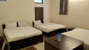 a room with two twin beds and a table at Arrow mansion in Kolli Hills