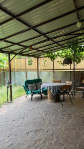 a covered patio with a table and a bench at Stara Praha Loft Rooms in Uzhhorod