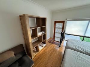 a bedroom with a bed and a couch and a window at Studio with private kitchenette and bathroom in Leumeah