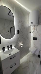 a white bathroom with a sink and a mirror at Przystanek Wałbrzych in Wałbrzych