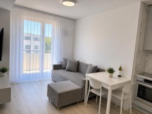 a living room with a couch and a table at Luxury White Residence in Trenčín