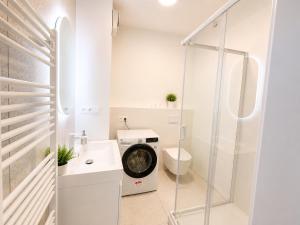 a bathroom with a washing machine and a toilet at Luxury White Residence in Trenčín +2 photos