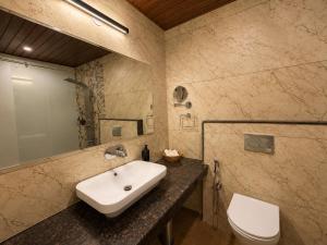 a bathroom with a sink and a toilet at The himalayan chester in Manāli +49 photos