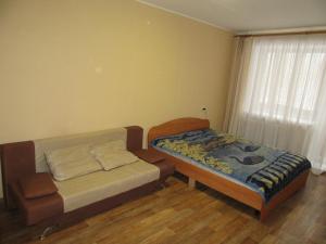 ペルミにあるApartments On Leninaのベッドルーム1室(ベッド1台、ソファ、窓付)