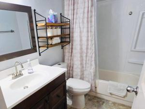 a bathroom with a sink and a toilet and a mirror at Siesta Sunset in Boise +40 photos
