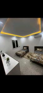 a room with two beds and a table in it at Villa baya in Djerba