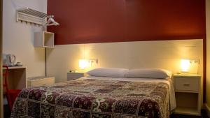 a bedroom with a bed with two lights on it at Hostal San Vicente II in Seville