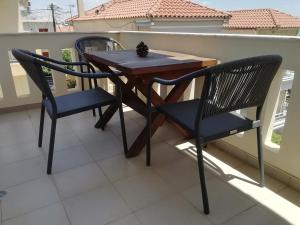 two chairs and a wooden table on a balcony at La petite maison in Xiropigado
