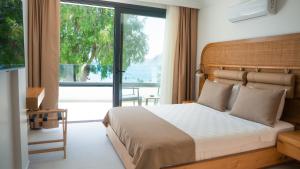 a bedroom with a bed and a large window at Blue Point Hotel Yalikavak in Yalıkavak +213 photos