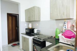 a kitchen with a stove and a sink at MtaaLiving-Bamburi in Mombasa +16 photos