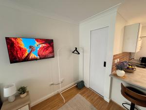 a living room with a tv hanging on a wall at Studio with private kitchenette and bathroom in Leumeah +2 photos