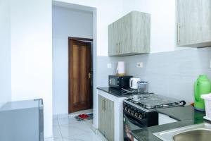 a kitchen with a stove and a sink at MtaaLiving-Bamburi in Mombasa