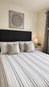 a bedroom with a large bed with a striped comforter at B by the sea in Scratby +27 photos