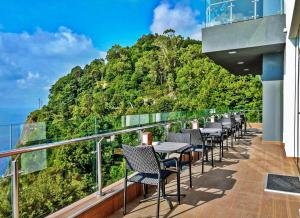a balcony with tables and chairs and a mountain at Hotel Montana in Sarpi +19 photos