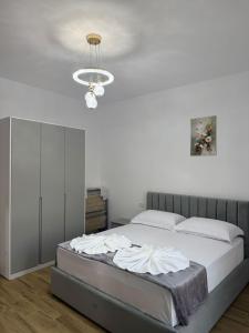 a bedroom with a bed and a chandelier at Arkej Pool Aparthotel in Golem +49 photos