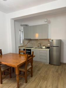 a kitchen with a wooden table and a refrigerator at Arkej Pool Aparthotel in Golem