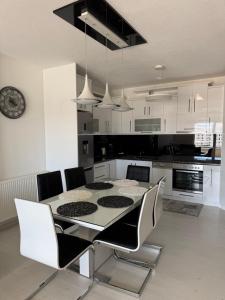 a kitchen with a table and chairs and a clock at Serenity Apartment in Struga