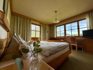 a bedroom with a bed and a vase of flowers at Pension Möslehnerhof in Ramsau am Dachstein