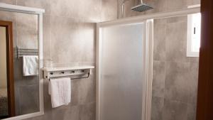 a shower with a glass door in a bathroom at Hostal San Vicente II in Seville