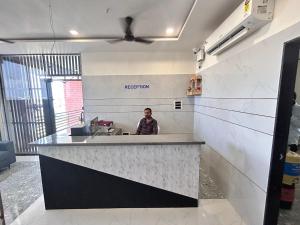 a man sitting at a counter in a kitchen at Hotel Madhav Palace in Māndvi