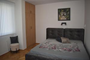 a small bedroom with a bed and a chair at Апартамент за гости Лале in Lovech