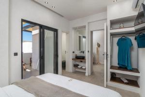 a white bedroom with a bed and a mirror at Ostria Vento in Pollonia +78 photos