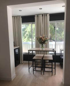 a dining room with a table with a vase of flowers at Sublime Sanary plage in Sanary-sur-Mer