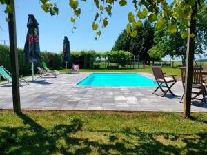 a swimming pool with two chairs and a table at apartma "happy Scotts" in Starše