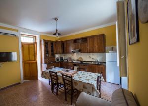 une cuisine avec une table avec des chaises et un réfrigérateur dans l'établissement La casa di Eolo, à Villa San Giovanni