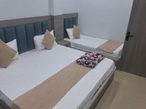 two twin beds in a room withthritisthritisthritisthritisthritisthritisthritisthritisthritis at HOTEL KRISHNAM Inn in Mathura